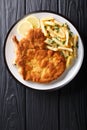 Traditional Italian veal Milanese with lemon and French fries cl