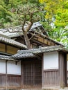 Traditional japan wooden temple with flowers and green trees in front of it Royalty Free Stock Photo