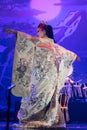 Traditional Japanese Actress in white traditional kimono with long sleeves dancing, back view