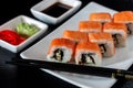 Traditional Japanese cuisine. Philadelphia sushi roll made of fresh salmon, avocado and cream cheese with black rice Royalty Free Stock Photo