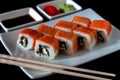 Traditional Japanese cuisine. Philadelphia sushi roll made of fresh salmon, avocado and cream cheese with black rice Royalty Free Stock Photo