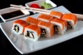 Traditional Japanese cuisine. Philadelphia sushi roll made of fresh salmon, avocado and cream cheese with black rice Royalty Free Stock Photo