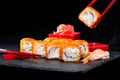 Traditional Japanese cuisine. Process of eating sushi rolls with Royalty Free Stock Photo