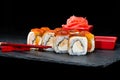 Traditional Japanese cuisine. Sweet sushi rolls with salmon, cream cheese, rice and banana was poured with jam on dark background Royalty Free Stock Photo