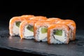 Traditional Japanese cuisine. Sweet sushi rolls with salmon, cream cheese, rice and kiwi on dark background, selective focus Royalty Free Stock Photo