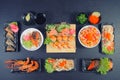 Traditional Japanese food - salmon salad sushi, rolls, rice with shrimp and sauce on a dark background. Top view Royalty Free Stock Photo
