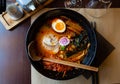 Traditional japanese noodle soup with shiitake mushroom, egg and greens served in ceramic bowl with wooden chopsticks Royalty Free Stock Photo