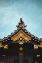 Traditional Japanese ornate wooden roof overhang with gold decoration in Kyoto.