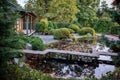 Traditional Japanese tea house with pond, wooden bridge, garden with stones and green bushes Royalty Free Stock Photo