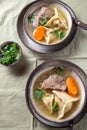 Traditional Jewish food dumplingd kreplach soup in gray bowl.