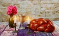 Traditional Jewish Sabbath Shalom ritual fresh challah bread on kiddush cup of red kosher wine