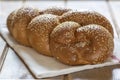 Traditional Jewish sweet Challah bread for Shabbat on a white textile on a wooden table. Royalty Free Stock Photo