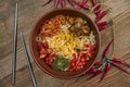 Traditional Korean wok noodles with hot pepper, meat, shiitake mushrooms and omelet in a ceramic plate on a wooden background. Top Royalty Free Stock Photo