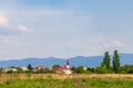 Traditional landscape of Transcarpathia. A church is visible on the horizon, and behind it are mountains.