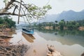 Traditional Laotian wooden slow boat on Nam Ou river near Nong Khiaw village, Laos