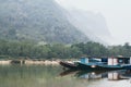 Traditional Laotian wooden slow boat on Nam Ou river near Nong Khiaw village, Laos Royalty Free Stock Photo