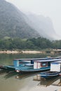 Traditional Laotian wooden slow boat on Nam Ou river near Nong Khiaw village, Laos Royalty Free Stock Photo