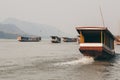 Traditional Laotian wooden slow boats on Mekong river near Luang Prabang, Laos