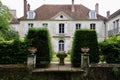 Traditional large French house with a red roof and hedge at the front. Crecy La Chapelle, France.