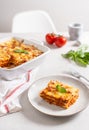 Traditional lasagna made with minced beef bolognese sauce and bechamel sauce topped with basil leaves on light background. Recipe Royalty Free Stock Photo