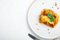 Traditional lasagna made with minced beef bolognese sauce topped with basil leafs, on plate, on white stone  background, top view Royalty Free Stock Photo