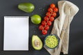 Traditional latinamerican mexican sauce guacamole in ceramic bowl and ingredients on dark background. Royalty Free Stock Photo