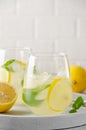 Traditional lemonade with lemon, mint and ice in a glass with metal straw on a gray concrete background. Refreshment summer drink Royalty Free Stock Photo