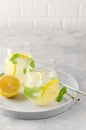 Traditional lemonade with lemon, mint and ice in a glass with metal straw on a gray concrete background. Refreshment summer drink Royalty Free Stock Photo