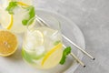 Traditional lemonade with lemon, mint and ice in a glass with metal straw on a gray concrete background. Refreshment summer drink Royalty Free Stock Photo