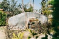 Traditional local off-grid retro style hothouse. Ecological countryside summer greenhouse with palms on the background