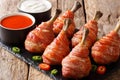 Traditional Lollipops chicken legs wrapped in bacon served with sauces close-up on a slate board. horizontal Royalty Free Stock Photo