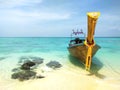 Traditional long tail boat with anchor in sand, Thailand