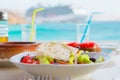 Traditional lunch with delicious fresh greek salad and brusketa served for lunch at outdoor restaurant with beautiful Royalty Free Stock Photo