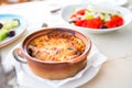 Traditional lunch with musaka and delicious fresh greek salad served for lunch at outdoor restaurant with beautiful view Royalty Free Stock Photo