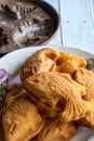 Traditional Malaysian cake called `kuih bahulu or baulu` in fish shape, in flowery plate over wooden background Royalty Free Stock Photo