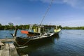 Traditional malaysian fisherman boat moored, wooden jetty and bl Royalty Free Stock Photo