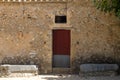 Traditional Mallorcan house with thick wooden door. Typical stone house of the Mediterranean. Holiday home to spend the summer in