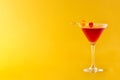 Traditional Manhattan cocktail with cherry on yellow background