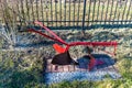 Traditional manual red plow made of steel, standing in the garden as an ornament.