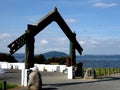 Traditional Maori Wooden carved gate in front of lake rotorua new zealand