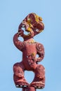 Traditional Maori wooden totem pole against blue sky