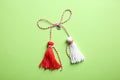 Traditional martisor on green background, top view. Beginning of spring celebration