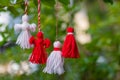 Traditional Martisor on green tree branch - symbol of 1 March, Martenitsa, Baba Marta, beginning of spring and seasons changing in