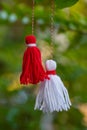 Traditional Martisor on green tree branch - symbol of 1 March, Martenitsa, Baba Marta, beginning of spring and seasons changing in