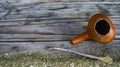 Traditional handcrafted mate cup made of calabash over a wooden table with yerba mate scattered over it