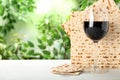 Traditional Matzos and glass of wine on wooden table, space for text. Pesach Passover celebration
