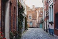 Traditional medieval architecture, narrow paved street with brick houses with red tiled roofs Royalty Free Stock Photo