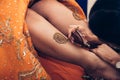 Traditional Mehndi henna pattern on female leg. Close-up photo.