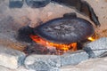 Traditional metal plate for making arabic pita bread cooking on fire in bedouin dwelling