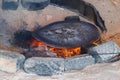 Traditional metal plate for making arabic pita bread cooking on fire in bedouin dwelling